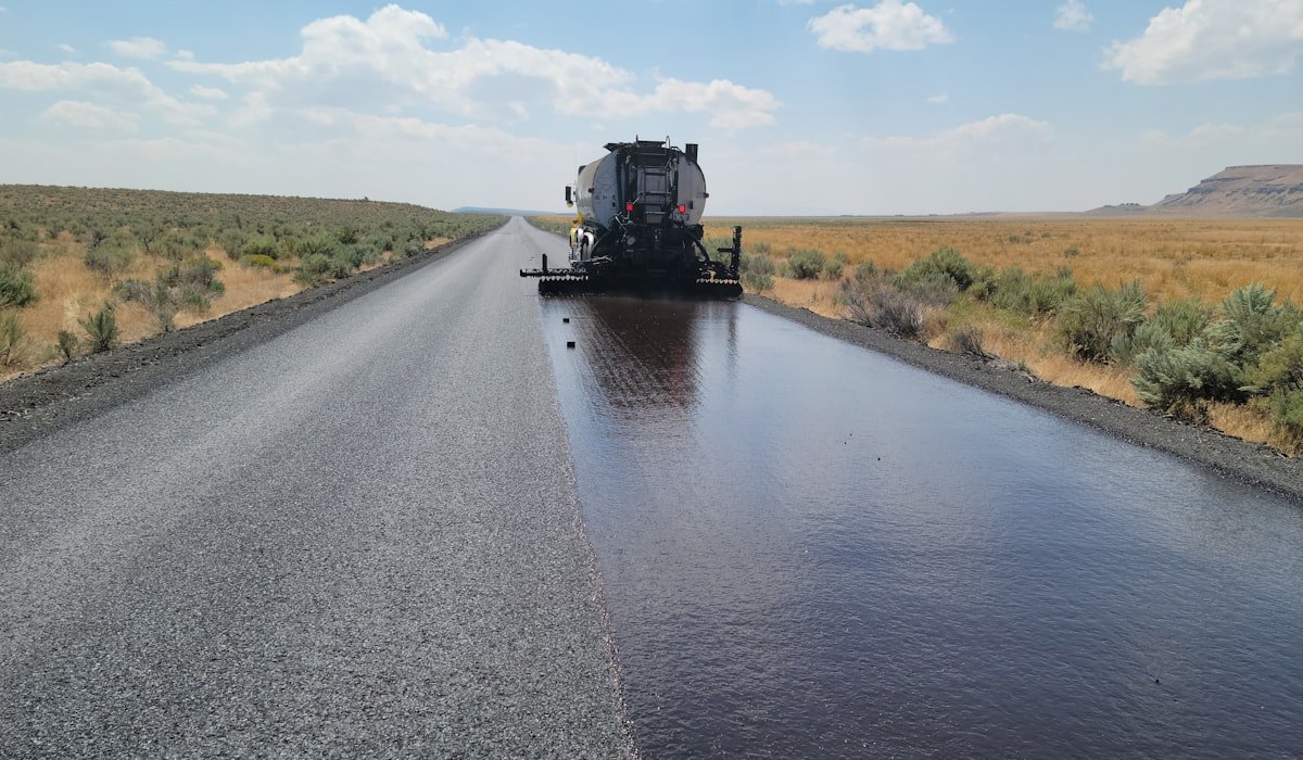 Paving crew placing fresh hot-mix asphalt with a paver on a Toronto street